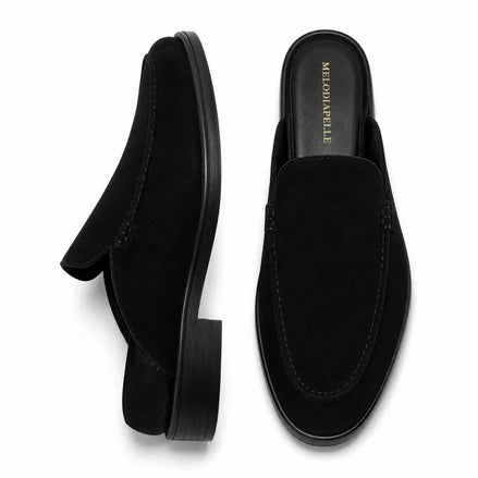 Black suede backless mule slipper, three-quarter angle showing heel and sole detailing