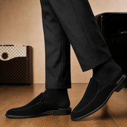 Melodiapelle Mila Mule in black suede worn with trousers, on-feet shot