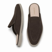 Dark brown suede backless mule slipper, three-quarter angle showing heel and sole detailing