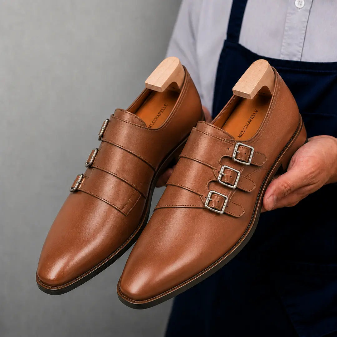 Man holding a pair of Melodiapelle Milan Triple Monk Strap Loafer shoes in tan leather, close-up