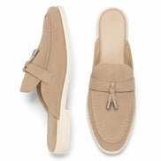 Sand beige suede apron-toe tassel mule, three-quarter angle showing tassel and sole detailing