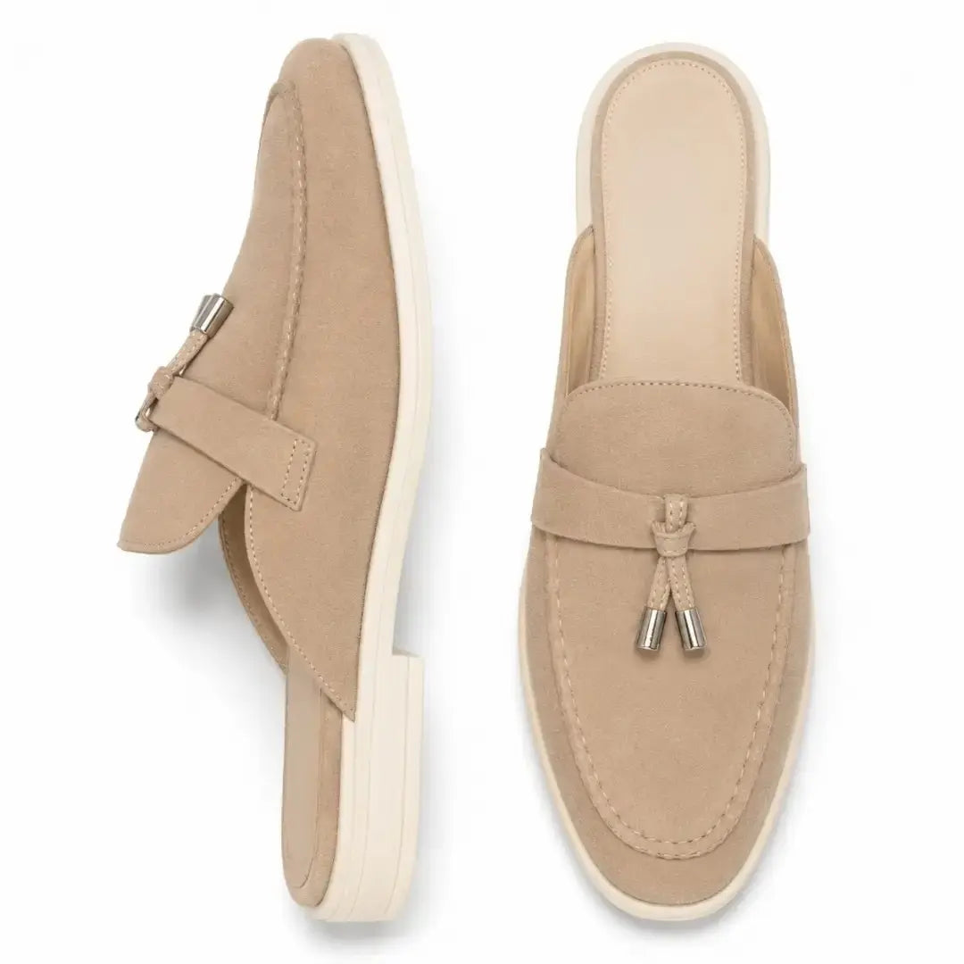 Sand beige suede apron-toe tassel mule, three-quarter angle showing tassel and sole detailing