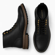 Black leather heritage boot, three-quarter angle showing cap-toe and heel detailing