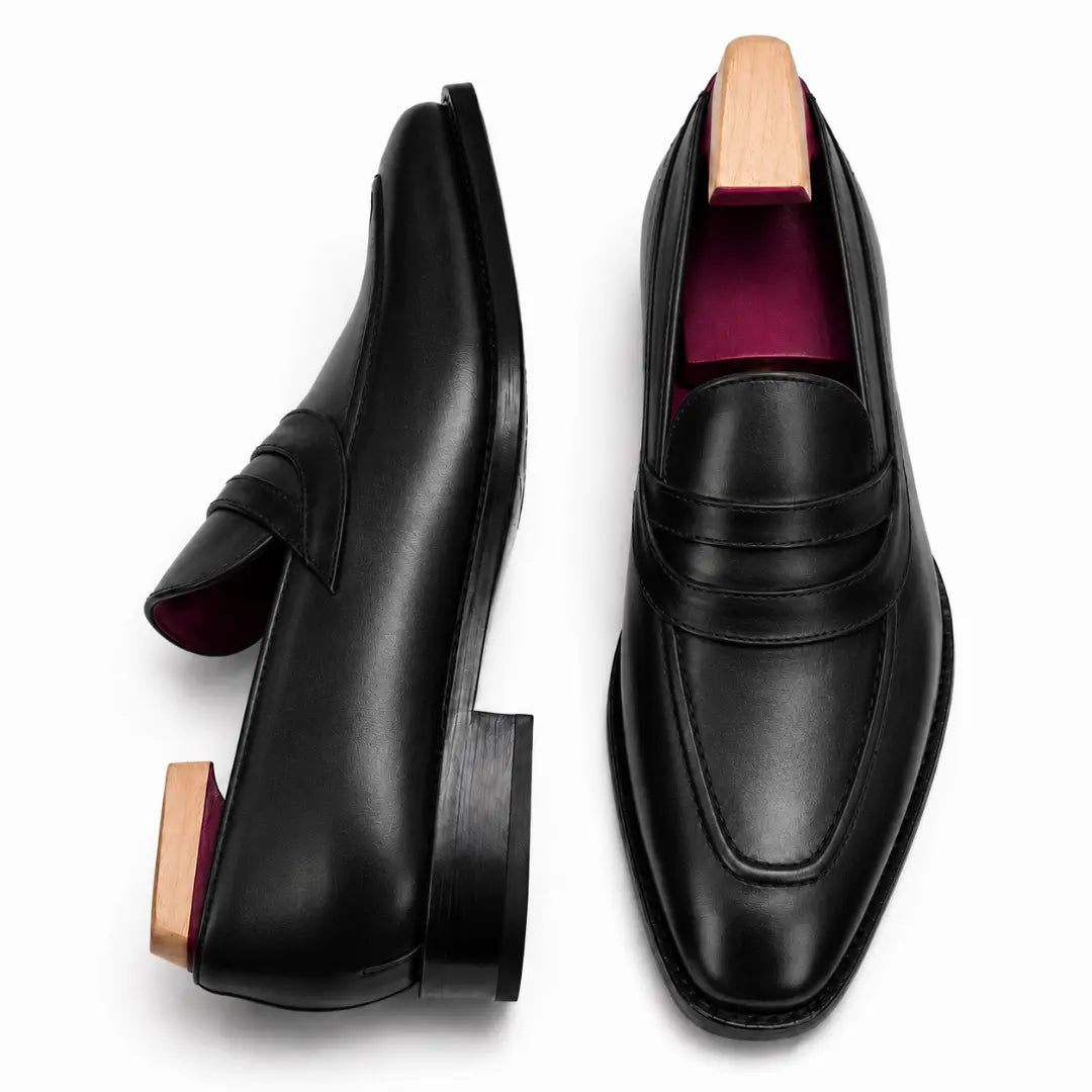 Black leather dress loafer, three-quarter angle showing band strap and heel
