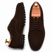 Dark brown suede plain-toe Derby, three-quarter angle showing heel and sole detailing