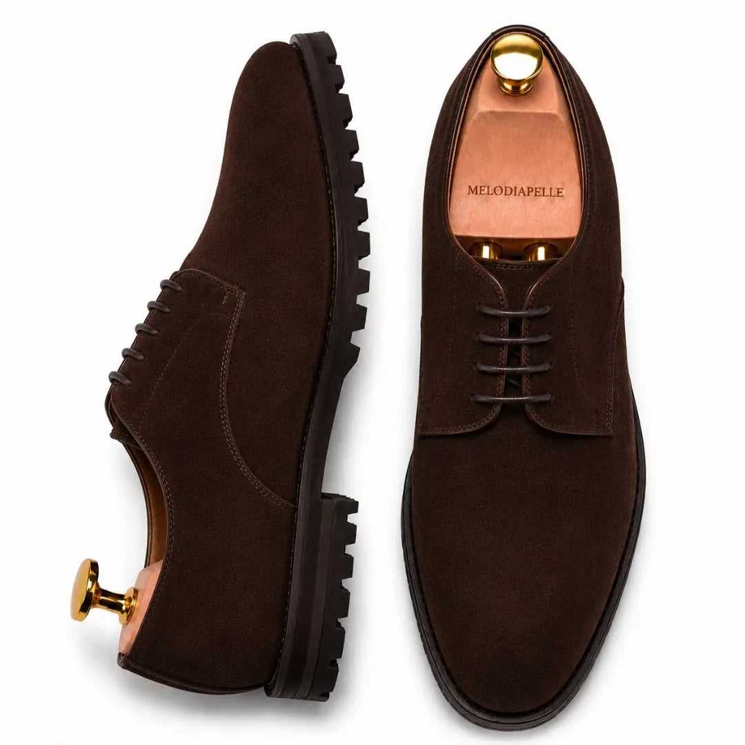 Dark brown suede plain-toe Derby, three-quarter angle showing heel and sole detailing