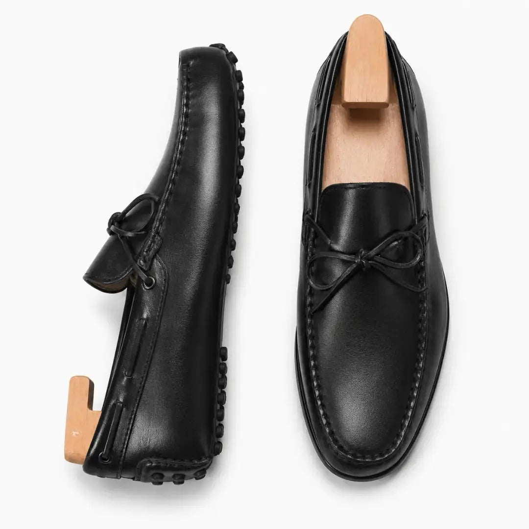 Black leather driving loafer with bow lace, three-quarter angle showing sole detailing