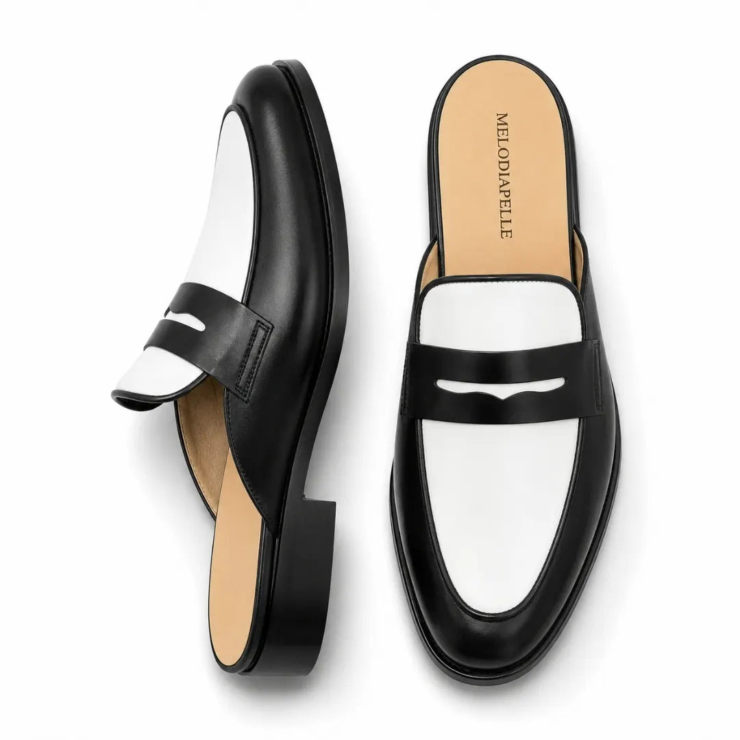 Black and white leather penny mule, three-quarter angle showing heel and two-tone detailing