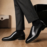 Melodiapelle Modesto Wholecut Oxford in black leather worn with formal trousers, on-feet shot