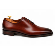 Side profile of the Modesto Wholecut Oxford in cognac tan leather on white background
