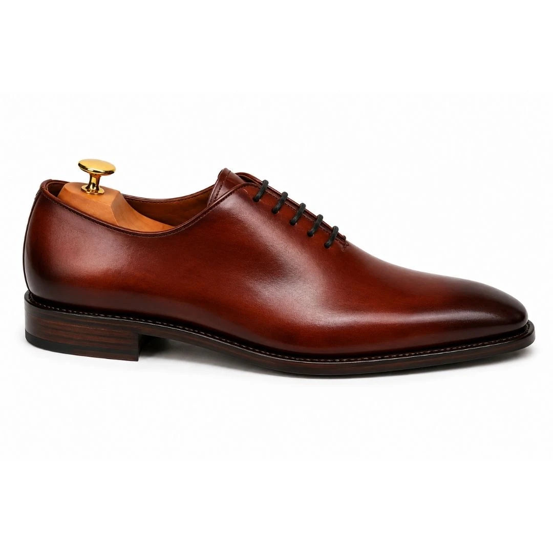 Side profile of the Modesto Wholecut Oxford in cognac tan leather on white background