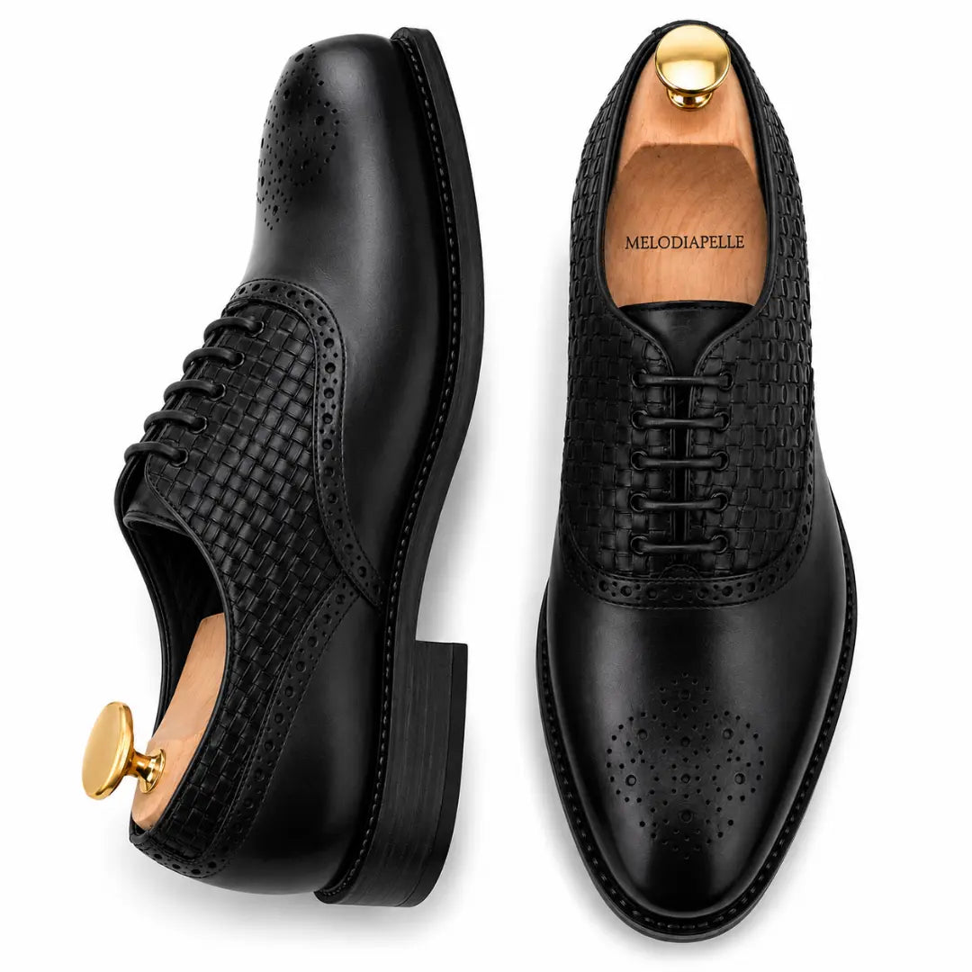 Man holding a pair of Melodiapelle Monaldo Woven Brogue Oxford shoes in black leather, close-up