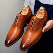Man holding a pair of Melodiapelle Monaldo Woven Brogue Oxford shoes in honey cognac leather, close-up