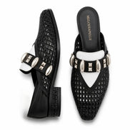 Black and white woven leather mule, three-quarter angle showing buckle strap and heel detailing