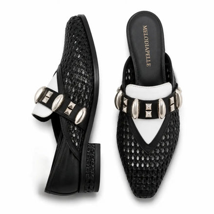 Black and white woven leather mule, three-quarter angle showing buckle strap and heel detailing
