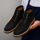 Man holding a pair of Melodiapelle Montblanc Heritage Lace-Up Boots in nero black leather, close-up