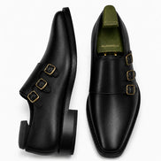 Black leather double monk strap shoe, three-quarter angle showing buckles and heel