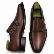 Dark chocolate leather double monk strap shoe, three-quarter angle showing buckles and heel