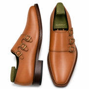 Tan leather double monk strap shoe, three-quarter angle showing buckles and heel