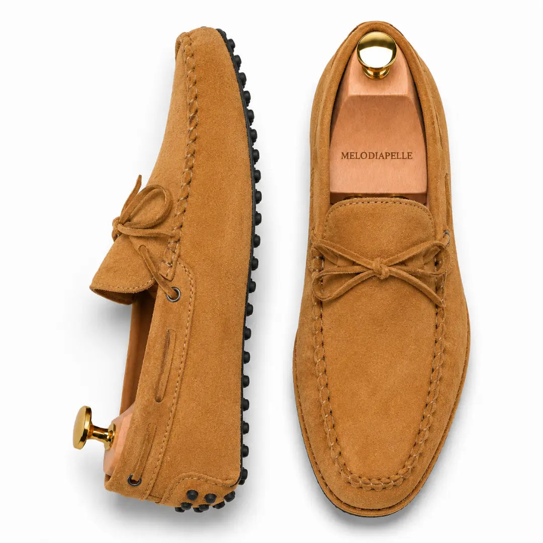 Camel tan suede driving loafer with bow lace, three-quarter angle showing sole detailing