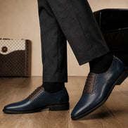 Melodiapelle Montserrat Two-Tone Saddle Oxford in navy and dark brown leather worn with formal trousers, on-feet shot