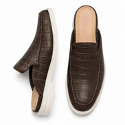 Dark brown croc-embossed leather mule, three-quarter angle showing heel and sole detailing