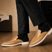 Melodiapelle Moreno Mule in sand beige croc-embossed leather worn with trousers, on-feet shot