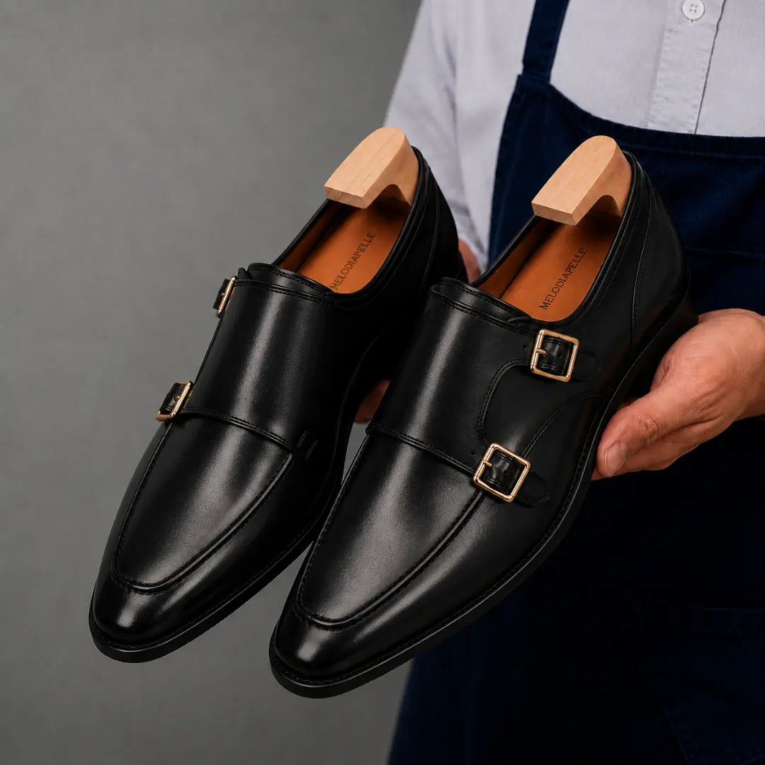 Man holding a pair of Melodiapelle Mortimer Apron Monk Strap shoes in black leather, close-up