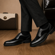 Melodiapelle Mosaic Two-Tone Wingtip Derby in nero black leather worn with formal trousers, on-feet shot