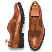 Tan leather two-tone wingtip Derby, three-quarter angle showing heel and brogue detailing