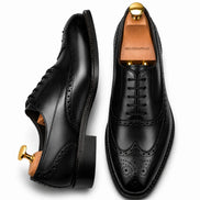 Black leather wingtip brogue Oxford, three-quarter angle showing heel and brogue detailing