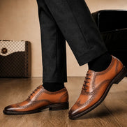 Melodiapelle Mossverde Wingtip Brogue Oxford in tan leather worn with formal trousers, on-feet shot