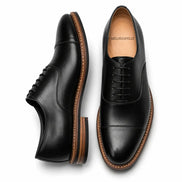Black leather cap-toe Oxford, three-quarter angle showing heel and toe detailing