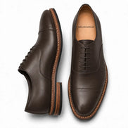 Dark brown leather cap-toe Oxford, three-quarter angle showing heel and toe detailing