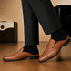 Melodiapelle Munar Mule in tan woven leather worn with trousers, on-feet shot