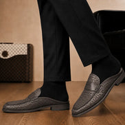 Melodiapelle Rossi Mule in dark brown woven leather worn with trousers, on-feet shot