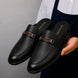 Man holding a pair of Melodiapelle Sergio Mule shoes in black leather, close-up